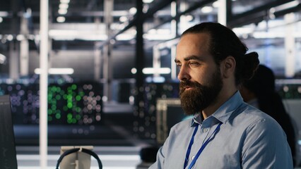 Smiling data center technician using PC to monitor neural network AI LLM visualization. Server room...