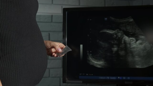Pregnant female hold condom. A view of pregnant female hold condom in her hands. A concept of birth control and refuse for contraception