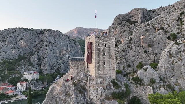 Drone close up of Mirabela Fortress above Omis old town, showing medieval stone walls and dramatic coastal backdrop.