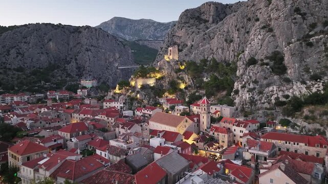 Aerial drone view of Church of Saint Michael and Mirabela Fortress in Omis during peaceful dusk light.