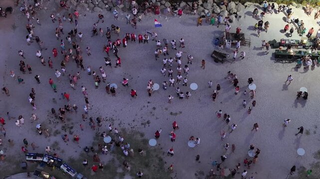 Drone footage of pirate themed performance in Omis with crowd and dramatic night atmosphere in historic square.