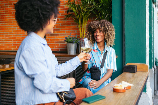 Two friends enjoying drinks at a downtown cafe