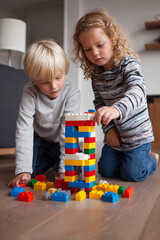 Fototapeta premium Playtime Adventure: Kids Building with Colorful Construction Toys for Creative Learning and Child Development at Home