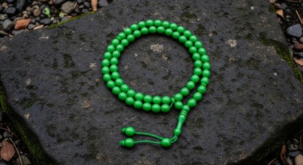 Green Beaded Necklace on Stone Background in Nature Setting