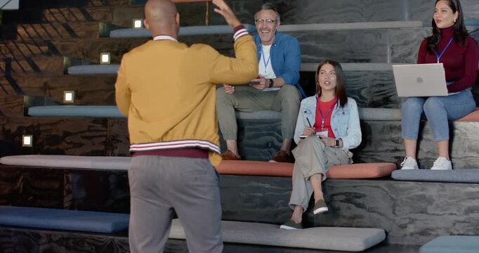 Welcome sparking male trainer gesturing, introducing group on training room benches, copy space