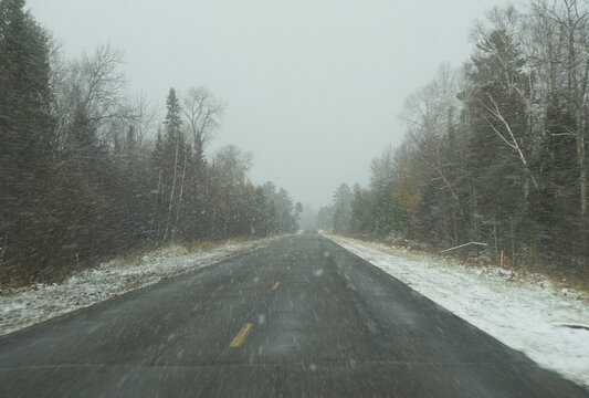 Driving up a snowy highway through the forest.