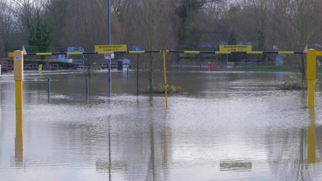 flooded car park parking lot, many gulls flying over flood water, reflections, ripples