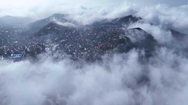 Breathtaking 4K aerial footage of Mount Lu in winter, showcasing snow-capped peaks, rolling sea of clouds, and frozen waterfalls in Jiangxi.