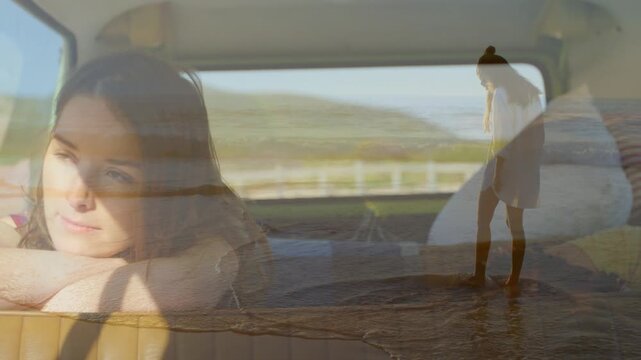 Woman reclining on van seat, fade overlay showing beach walker moving across window, travel memory