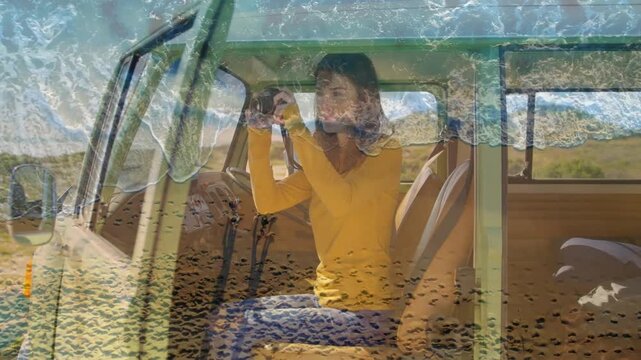 Woman lifting camera, shooting inside parked van for travel, wave overlay blending across her view