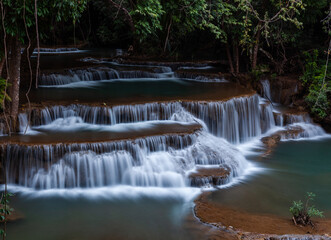 Huay Mae Khamin Waterfalls cascading down rocky terraces. Located in Kanchanaburi, Thailand. Surrounded by lush green tropical forest in Sri Nakarin Dam National Park.