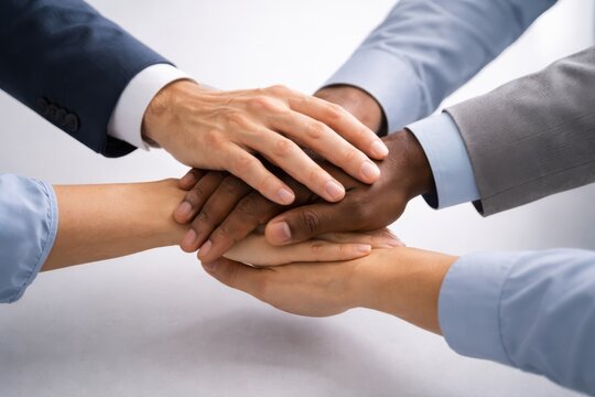 Diverse business team stacking hands in unity and cooperation
