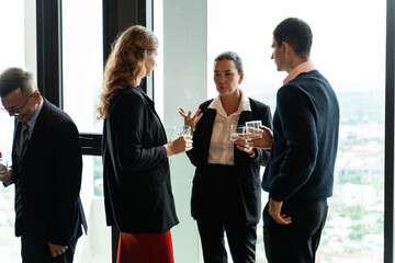 Executives connecting during discussion at event in a modern hotel lounge,symbolizing...