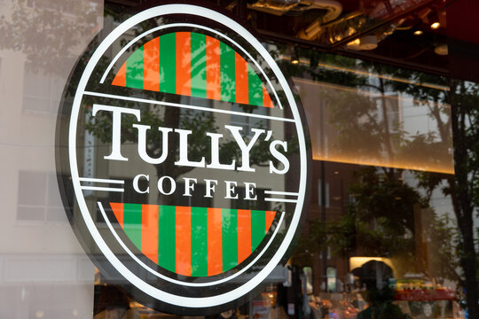 TOSHIMA, TOKYO, JAPAN - FEBRUARY 24, 2026: The circular green and brown logo of Tully's Coffee, a popular coffee house chain, displayed outside a shop in Toshima City.