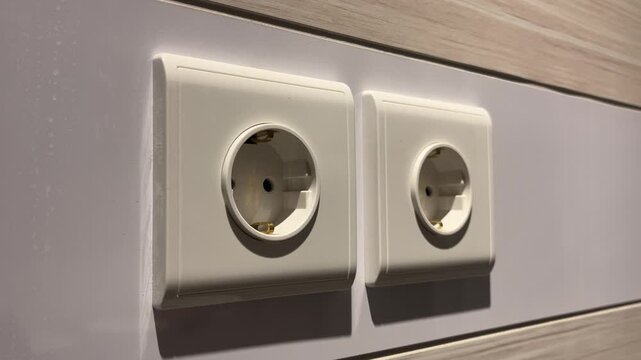 close up view of a white electrical outlet are mounted on white wall. Concept of energy deficit and conscious consumption of resources. Stop contact. wooden, wood, hardwood. 