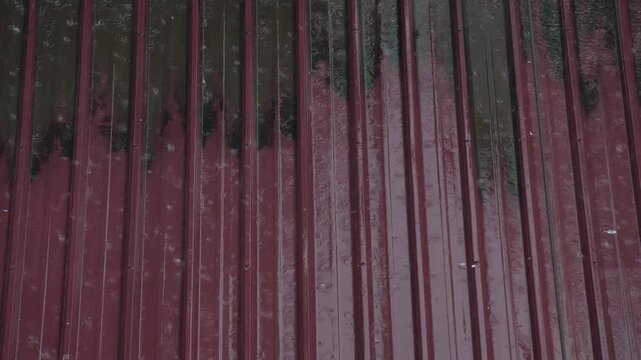 Intense rain hitting a red corrugated metal roof. Ideal for industrial, rural, or weather-heavy storytelling and ASMR mood.