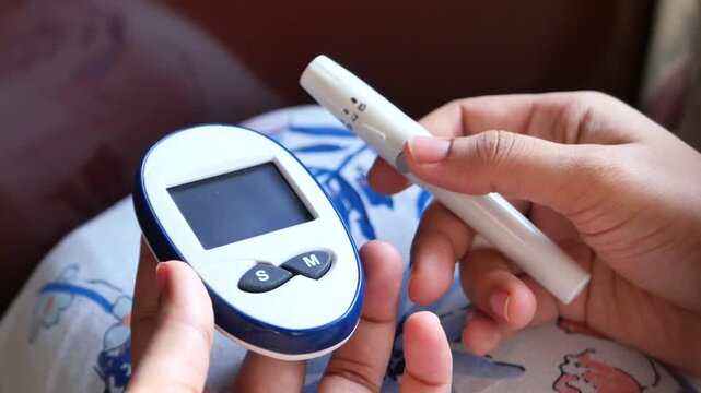 Woman holding blood glucose monitor and lancing device for diabetes testing at home