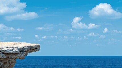 Tranquil Coastal Landscape with Cliffs and Calm Blue Ocean Under a Bright Sky Full of White Fluffy Clouds