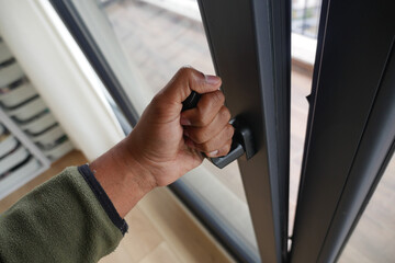 Opening a door with a hand during daytime