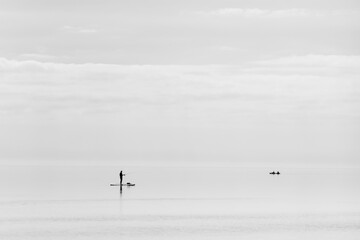 Silhouettes of a man on a paddle board and kayak on Biscayne Bay, Florida