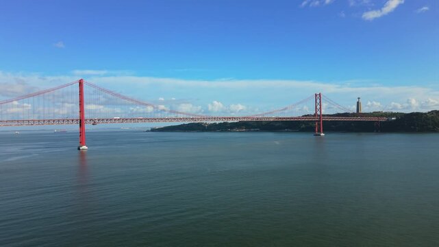 Aerial view of April Bridge. inspection drone over red suspension bridge Lisbon close approach to steel tower and cables structural survey vibe measurement sensors maintenance context