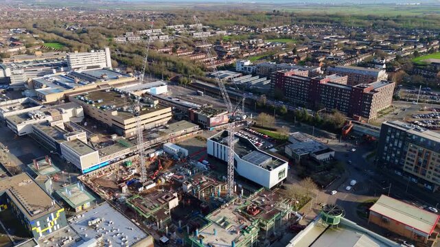 Reverse aerial view of Basildon, UK, showing a construction site and the cityscape