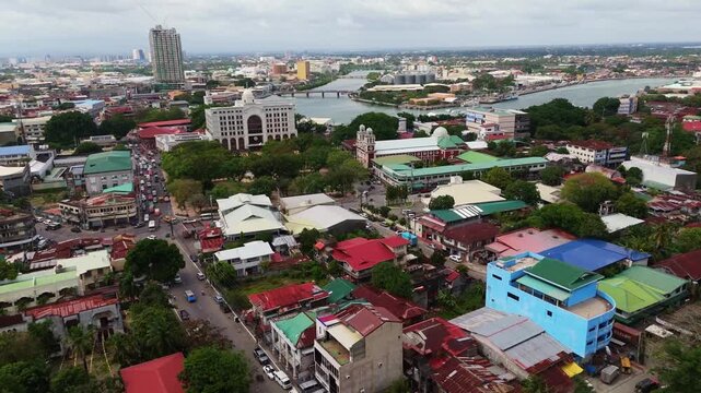 Panoramic aerial drone shot of the historic Plaza Libertad in Iloilo City, showcasing the central square with the scenic Iloilo River winding in the background