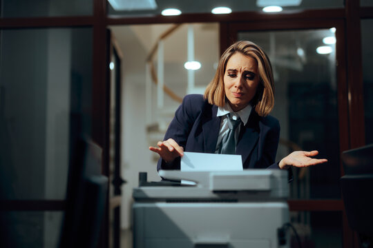 Frustrated Businesswoman Looking Confused while Trying to use a Printer. Stressed female professional appearing perplexed while troubleshooting a malfunctioning copier 

