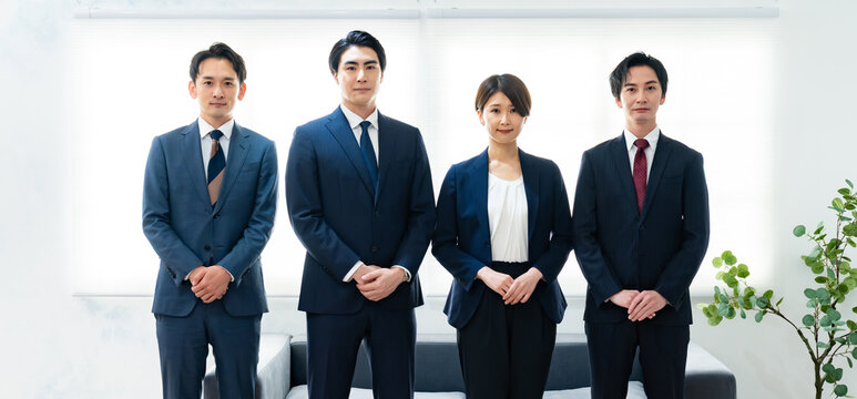 日本人ビジネスパーソン4名がネクタイ・スーツで並ぶ・会社紹介・採用・チーム写真