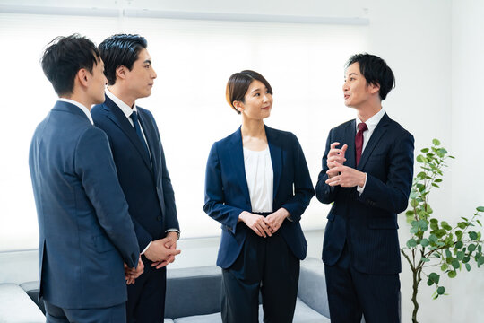 オフィスで会話する日本人ビジネスチームのミーティング風景