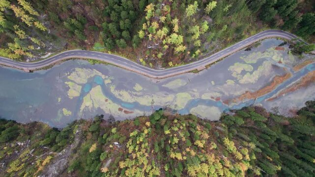 Drone view of Jiuzhaigou National Park in autumn in Sichuan Province China. It features cascading waterfalls, turquoise blue lakes, and stunning mountain valleys. 4K real time footage travel concept