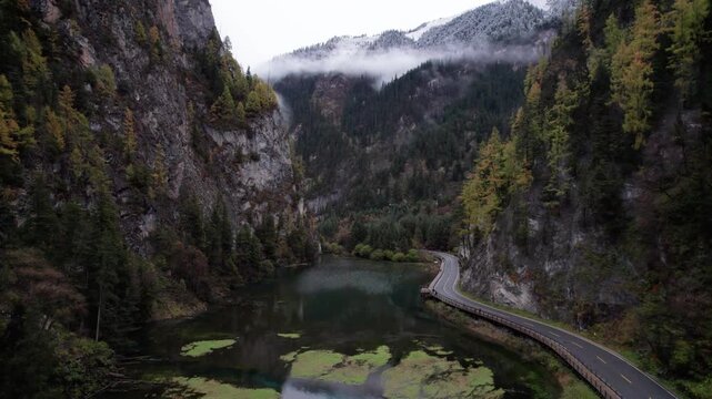 Drone view of Jiuzhaigou National Park in autumn in Sichuan Province China. It features cascading waterfalls, turquoise blue lakes, and stunning mountain valleys. 4K real time footage travel concept