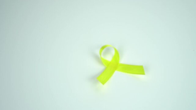 A woman's hand is holding a blue ribbon symbolizing awareness and support for Sarcoma or Bone Cancers, Bladder Cancer, isolated on a white background