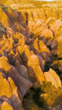 Vertical video. Goreme, Nevsehir, Turkey. Educational view of Devrent Valley showing interesting erosion patterns and geological features at dusk.. Aerial View. Rich colors