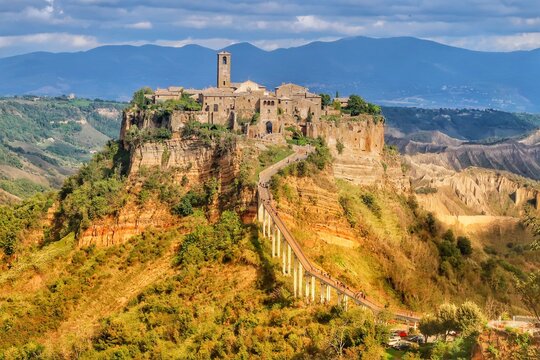 Dramatic View of Civita di Bagnoregio &ndash; The Dying City Hilltop Village on Tuff Cliff, Lazio Italy with Pedestrian Bridge and Badlands Landscape