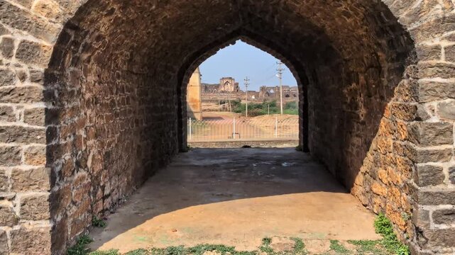 Symmetrical view of ancient stone archways inside a historic bidar fort at karnataka, india. day time, hand held shot, push in shot, 4k.