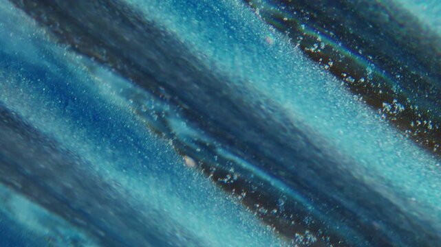 Ink wave defocused. Lens fluid. Glitter stripe trickles stream mix color abstract background. Blue black particles spill with prism effect.