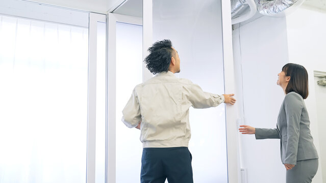 ガラスパーティションを修理する作業員