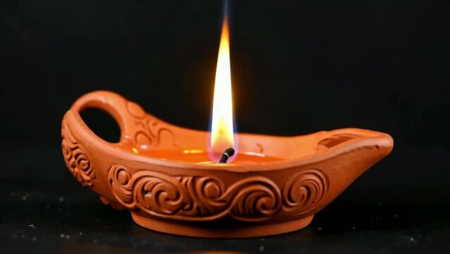 Close up of lit diya oil lamp flame on dark background, Diwali or Hindu spiritual light concept