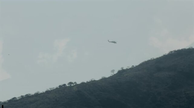 Military or National Guard helicopter flies over Cerro Cihuapilli in search and detain operation, Tuxpan, Jalisco, Mexico