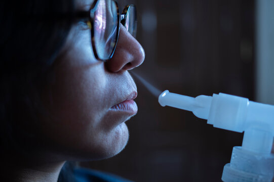 Mujer joven hispana Mexicana en tratamiento de nebulizacion en casa por problemas respiratorios de bronquitis y asma. Close Up o Macro.