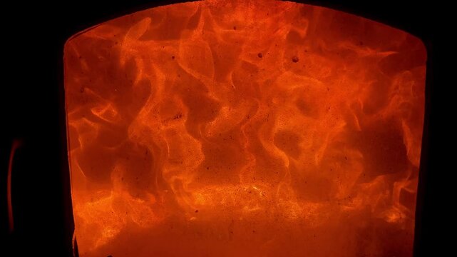 Burning fire flames providing comfort and warmth in a fireplace. A glowing orange background abstract texture