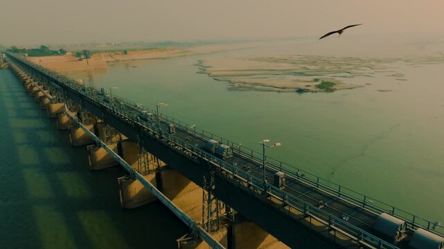 Aerial view of Kotri Barrage dam and bridge spanning the Indus River in Sindh, Pakistan at sunrise.