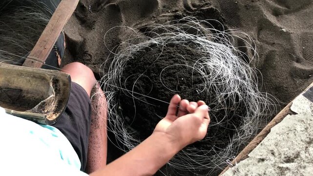 fisherman is attaching multiple hooks to a nylon fishing line.