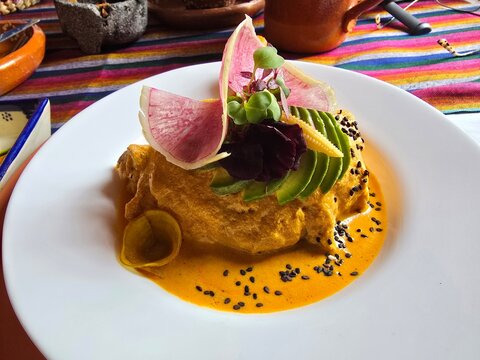 Mexican pipi&aacute;n dish served with meat, avocado and traditional garnish.
