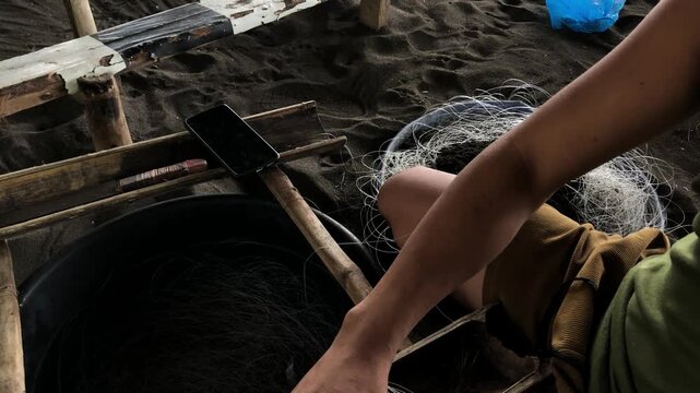 fisherman is attaching multiple hooks to a nylon fishing line.