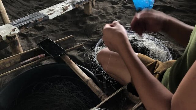 fisherman is attaching multiple hooks to a nylon fishing line.
