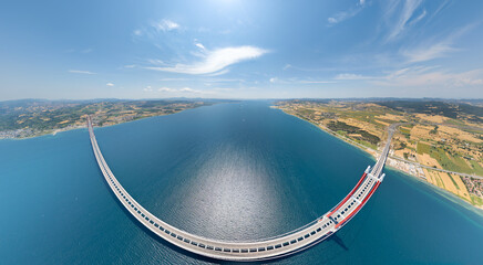 Fototapeta premium Lapseki, Turkey. Panoramic aerial view of 1915 Canakkale Bridge over Dardanelles Strait with highway, fields and ships on horizon on summer day. Aerial view