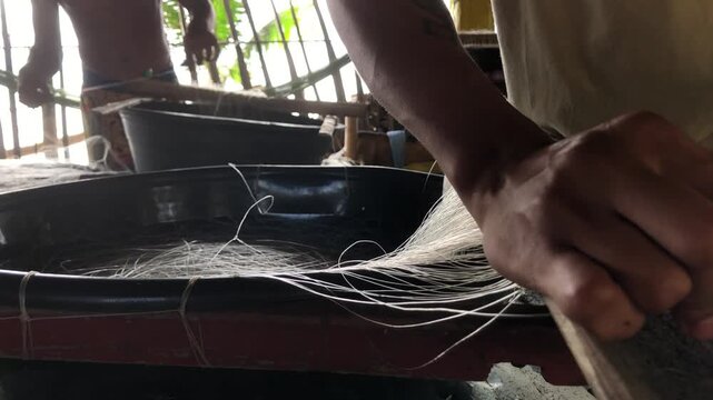 fisherman is attaching multiple hooks to a nylon fishing line.