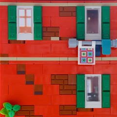 Fototapeta premium Tambov, Russian Federation - January 05, 2026 Close-up of facade of red Lego building, featuring green shutters, white-framed windows.